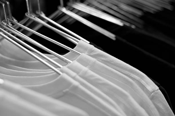 White and black T-shirts on cloth hangers in row