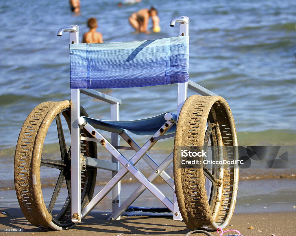 車椅子に穴あきウィールズ海のビーチ - テクノ��ロジーのロイヤリティフリーストックフォト