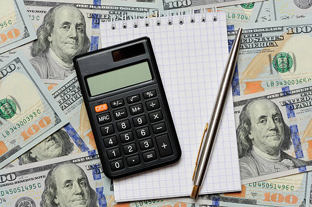 Dollars, notepad, pen and calculator stock photo