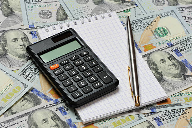 Dollars, notepad, pen and calculator stock photo