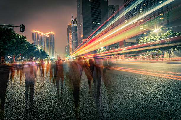 blur people and traffic on a street at night blur people and traffic on a street at night, long exposure. street light stock pictures, royalty-free photos & images