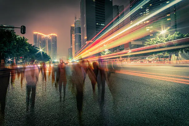 Photo of blur people and traffic on a street at night