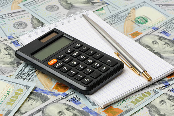 Dollars, notepad, pen and calculator stock photo