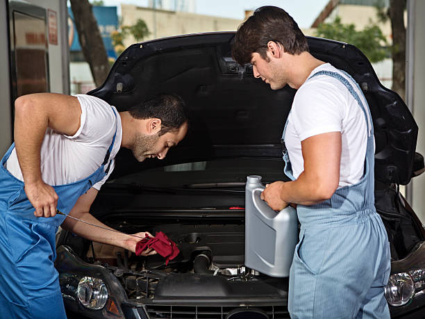 junge, die auto-mechaniker arbeiten am auto reparieren shop - vehicle breakdown hood car oil change stock-fotos und bilder