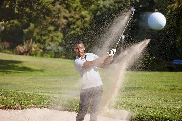 Shot of a handsome young man playing a game of golf