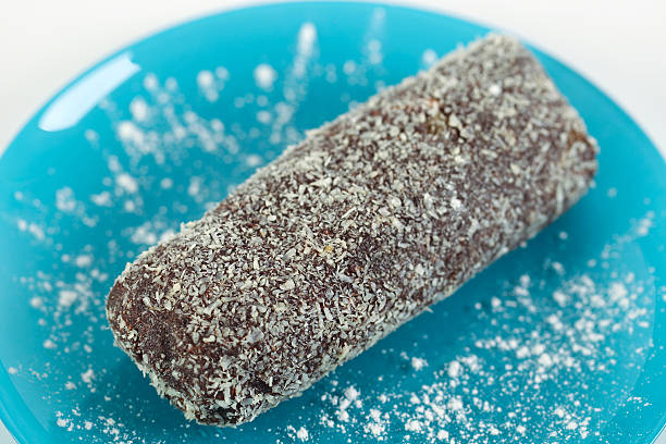 istock Delicious chocolate sausage with coconut on blue plate 504106187