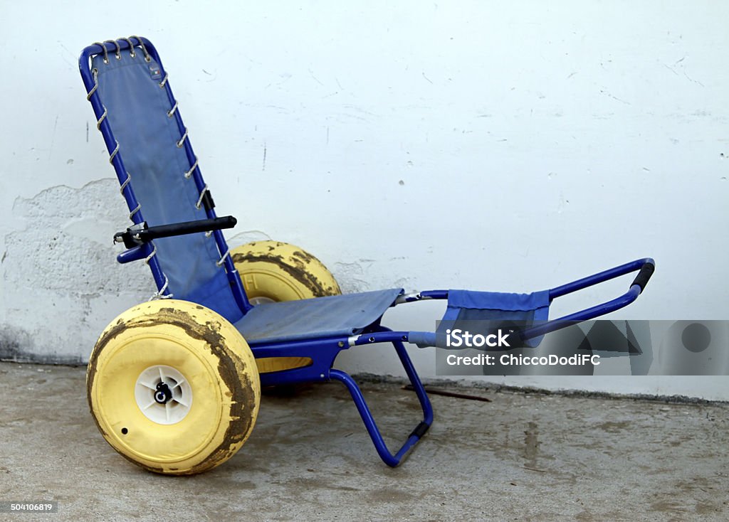 Blu sedia a rotelle con ruote con pneumatici in gomma - Foto stock royalty-free di Ambientazione esterna