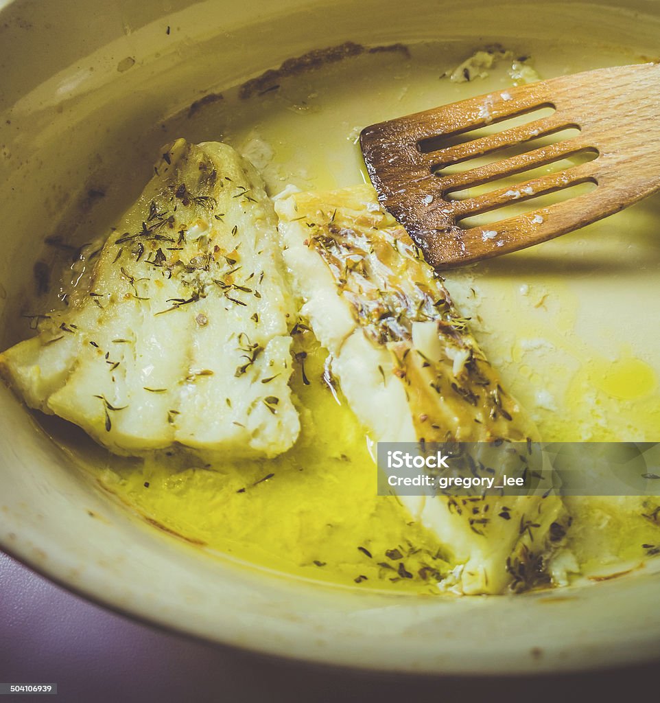 Fish Closeup of ceramic dish with baked fish seasoning with herbs. Toned picture Auto Post Production Filter Stock Photo