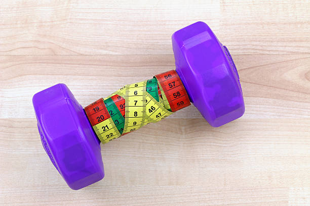 istock Purple dumbbell with measuring tape 504107183
