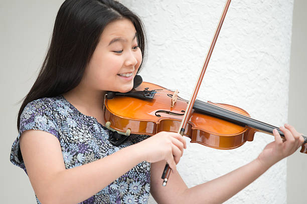 istock Girl Playing Violin Attentively 504107404