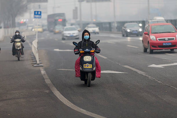 bicicleta elétrica em beijing - smog china beijing pollution - fotografias e filmes do acervo