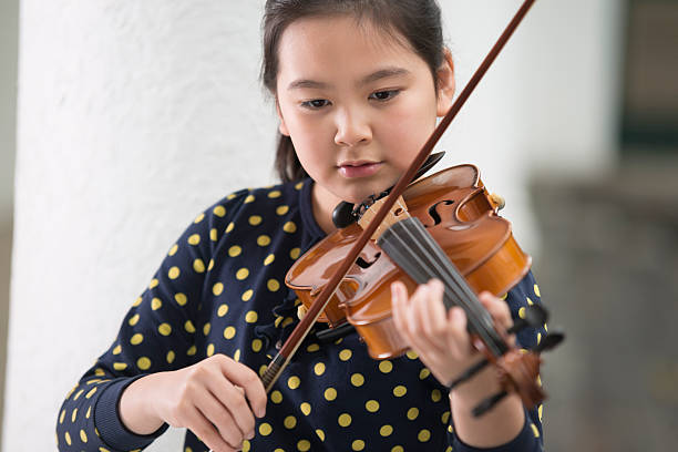 istock Cute Girl Playing Violin 504110618
