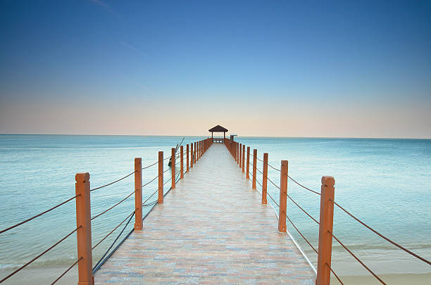 istock long pier heading to the sea under  beautiful blue sky. 504111570