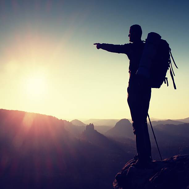 istock Sharp silhouette of a tall man on top of mountain 504112810