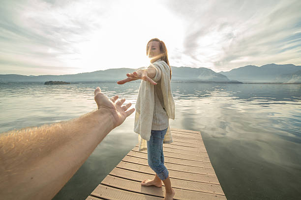 istock Young woman walking on a jetty holding a man's hand. 504113150