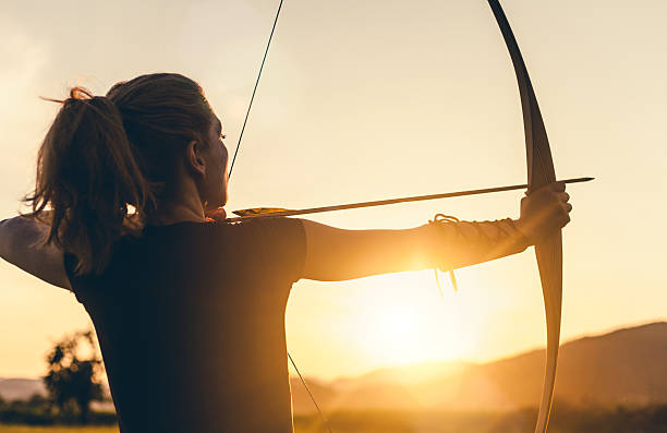 frau schießen mit einem langbogen - archery bow arrow women stock-fotos und bilder