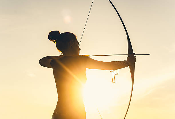 frau schießen mit einem langbogen - archery bow arrow women stock-fotos und bilder