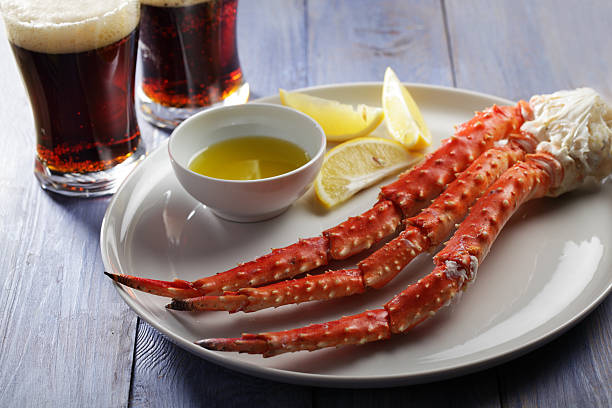 Red king crab legs and beer Red king crab legs with lemon and beer on a rustic table crab leg stock pictures, royalty-free photos & images