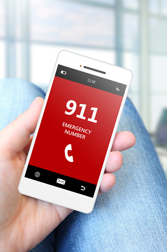 hand holding mobile phone with emergency number 911. focus on phone.
