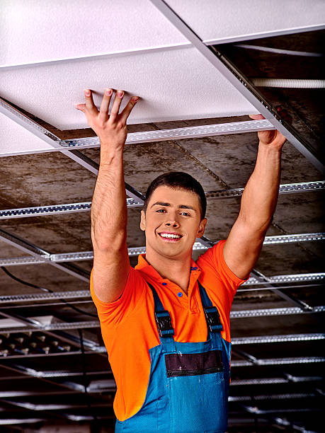 Man installing suspended ceiling stock photo
