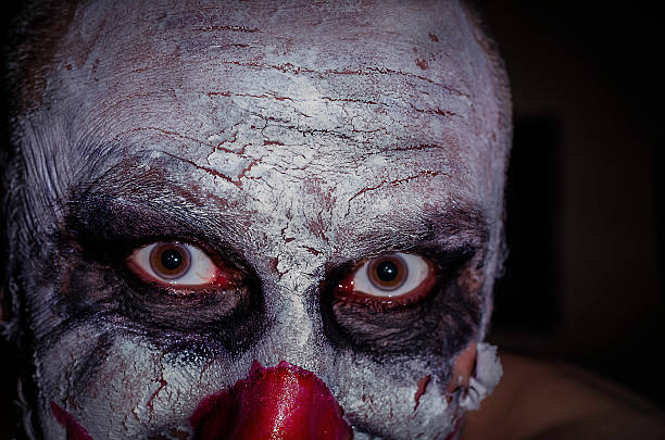 scary horror clown face  isolated on a black background colour image
