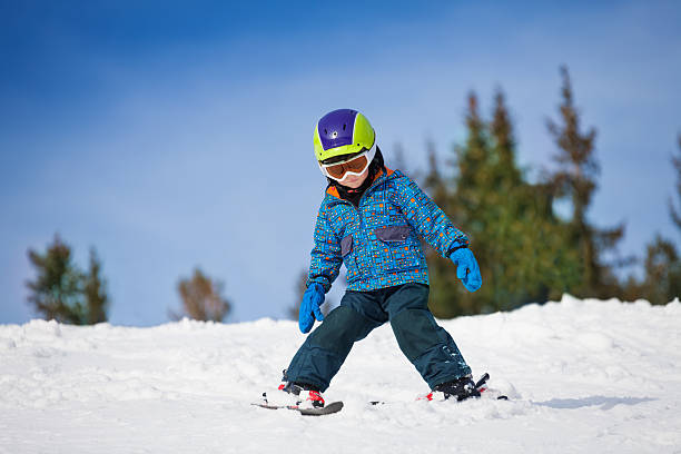 istock Small boy in ski mask and helmet learns skiing 504128877