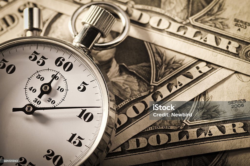 Stop watch and dollar Old analog stop watch on dollar Currency Stock Photo