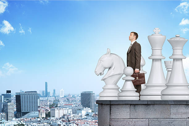 istock Businessman standing with big chess figures 504131378