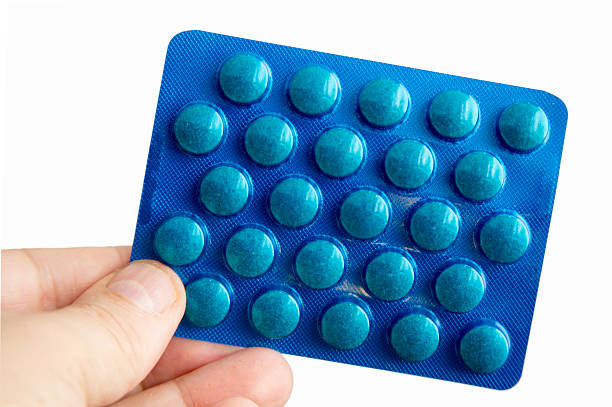 istock hand holding blue pack Capsules, isolated on white background 504131483