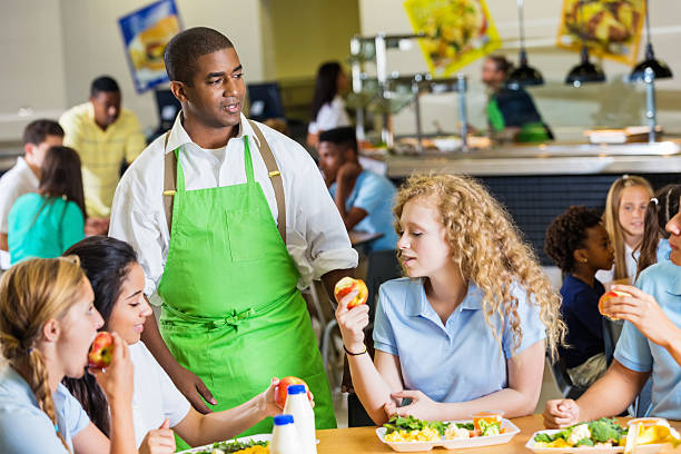 istock Students enjoy apples and chat during school lunch break 504134129