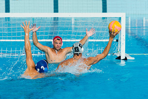 Water Polo Scoring Action in front of Goal Front view of young water polo players having goal action water polo photos stock pictures, royalty-free photos & images