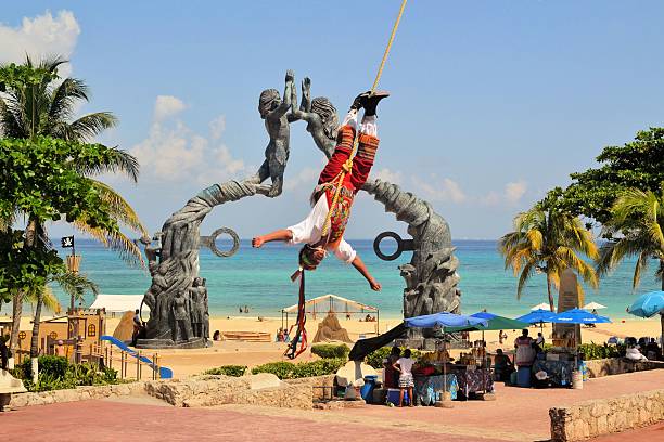 Voladores Acrobat performers at Flying Men Traditional Dance Ceremony in Playa del Carmen, Riviera Maya, Yucatan, Mexico - 19 August 2013: Acrobat performers, so-called Voladores, perform a Flying Men Dance ceremony near the beach of Playa del Carmen. The fertility ritual is a traditional Ceremony of Mayans and other tribes to please the God of rain. volador stock pictures, royalty-free photos & images