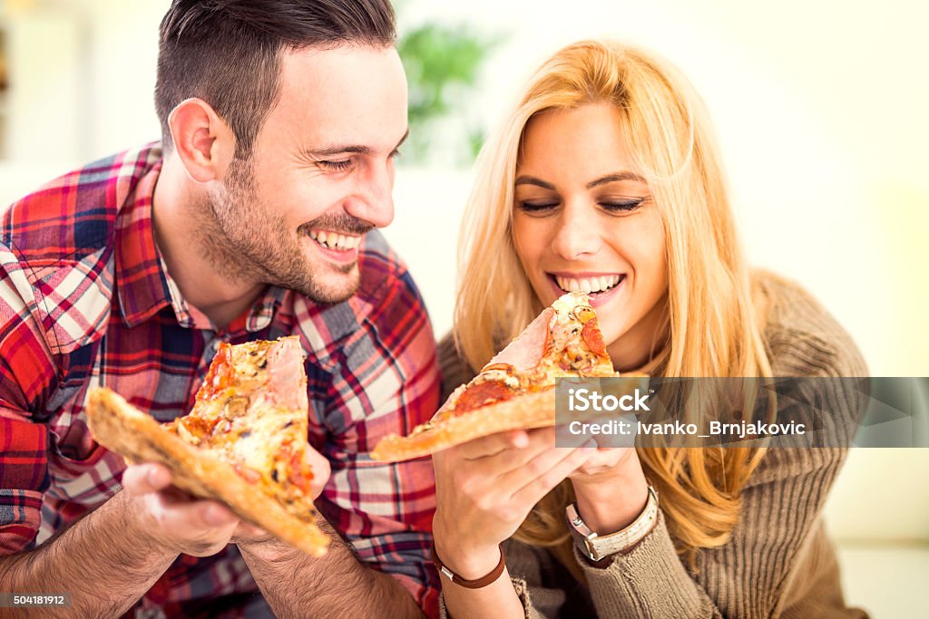 Pizza Portrait of an happy couple.They are laughing and eating pizza and having a great time. 20-29 Years Stock Photo