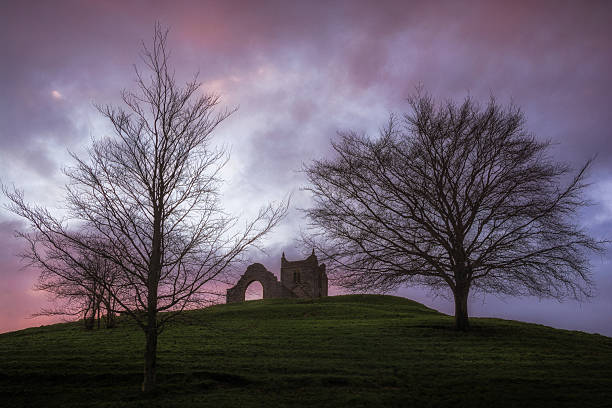 Burrow Mump Church Ruins Burrow Mump is a hill and historic site overlooking Southlake Moor in the village of Burrowbridge within the English county of Somerset. It is a scheduled monument, with the ruined church on top of the hill a Grade II listed building. burrow somerset stock pictures, royalty-free photos & images