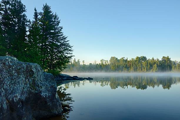 Morning Reflections on a Foggy Wilderness Lake stock photo