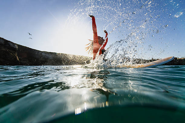 woman sitting on the surfboard and doing splashes