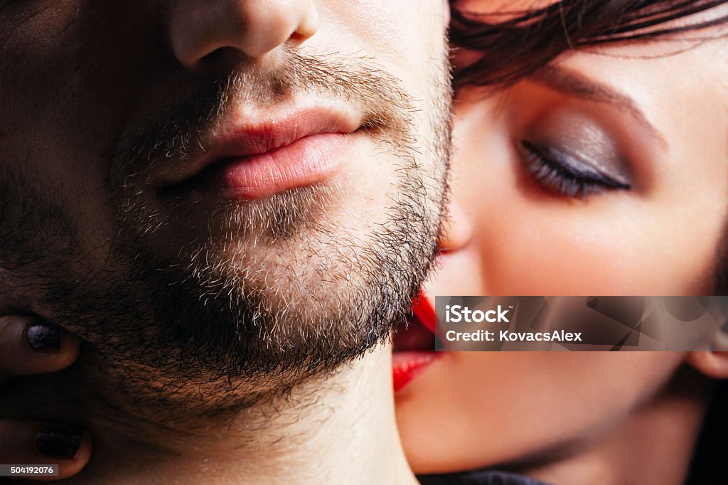 Woman kissing a man on the neck Close up of a women passionately kissing a man on the neck. Kissing Stock Photo
