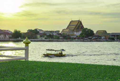 selected focus at artificial turf, sunset at Chao Praya riverside