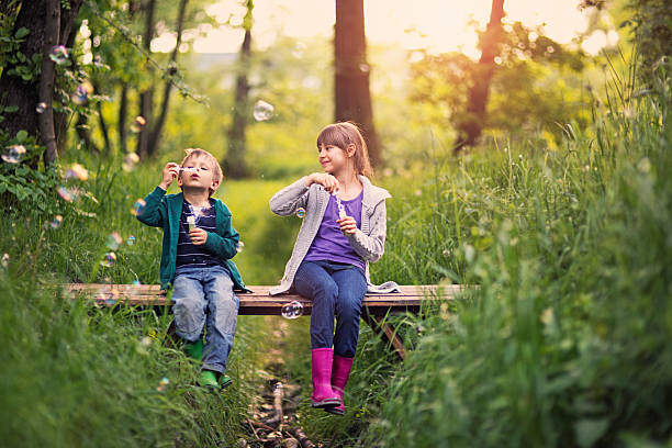 Brother and sister blowing  bubbles