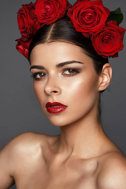 istock serious young brunette with red roses and red lipstick 504220796