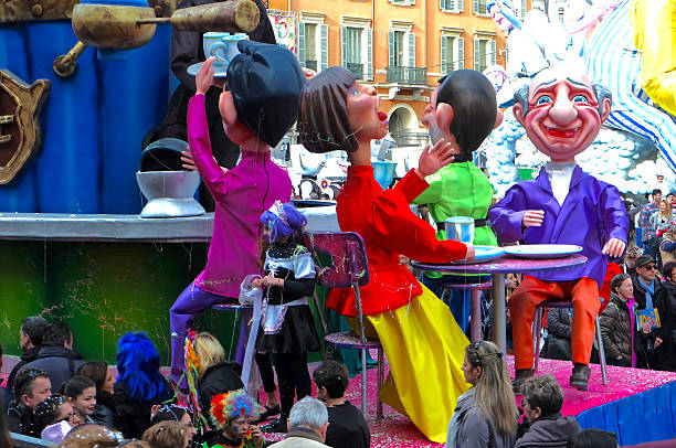 Nice, Provence-Alpes-Cote d'Azur, France - March 5, 2014: A float with 4 giant figures highlighting coffee culture, along with crowds of revellers at the 2014 Nice Carnival.
