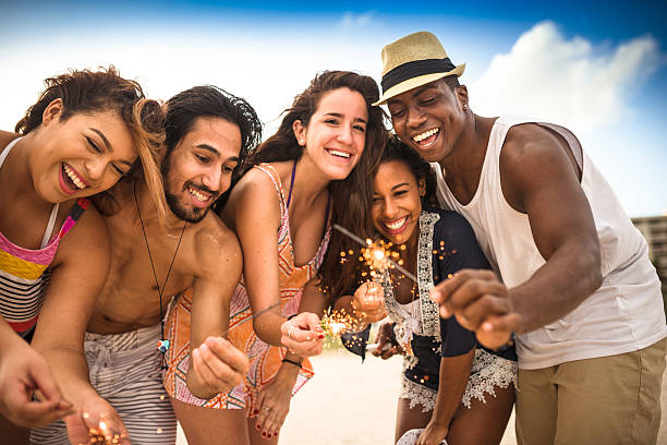 istock friends using a sparkler togetherness on the beach 504224188