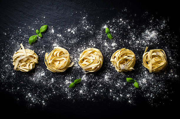 pasta su sfondo scuro - italian cuisine dry pasta directly above foto e immagini stock