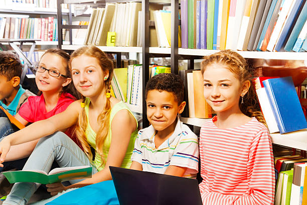 istock Five smiling children sitting in a row on floor 504237067