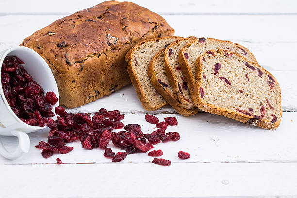 Bread with cranberries on white wooden board