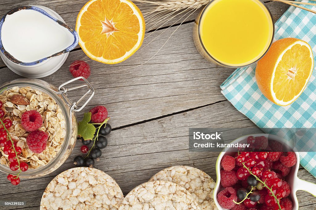 Healty breakfast with muesli, berries and orange juice Healty breakfast with muesli, berries and orange juice. View from above on wooden table with copy space Above Stock Photo