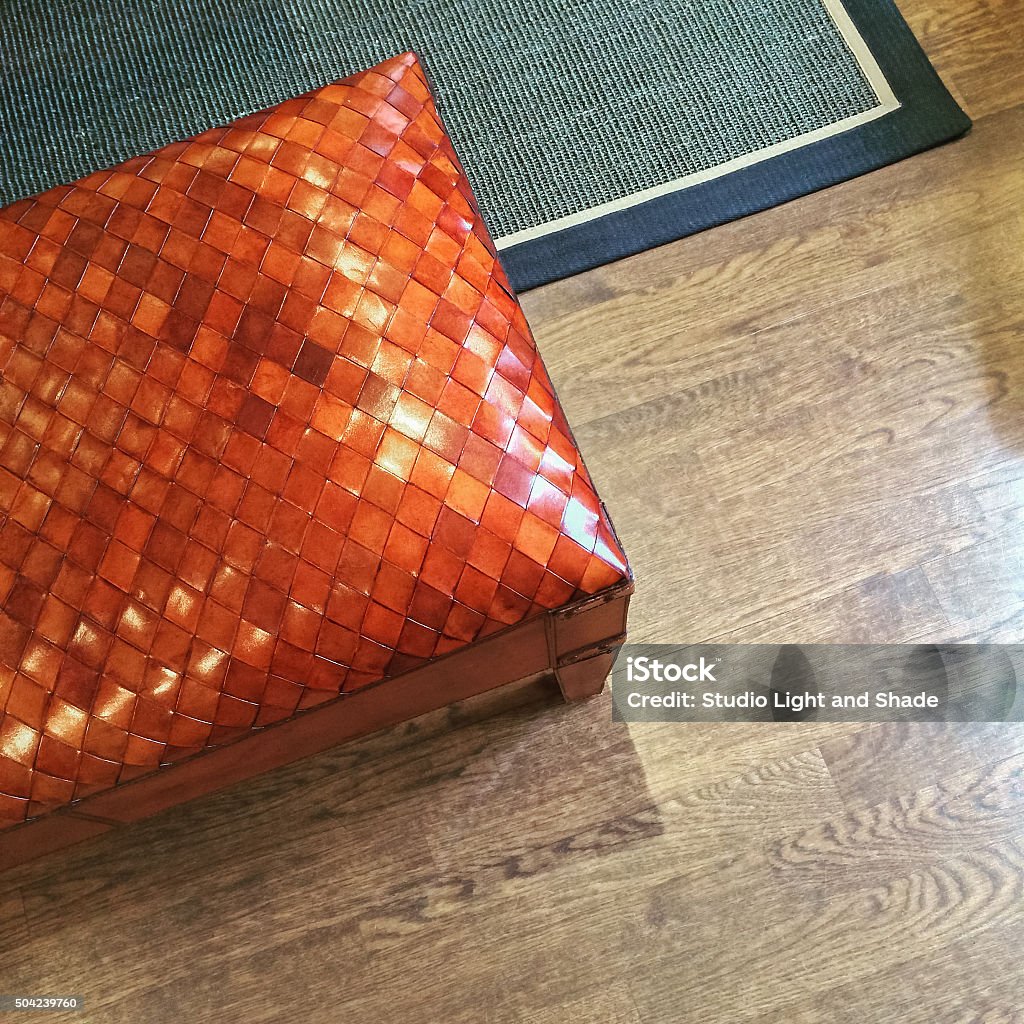 Orange leather bench on wooden floor Orange leather bench on wooden floor. Interior detail. Furniture Stock Photo