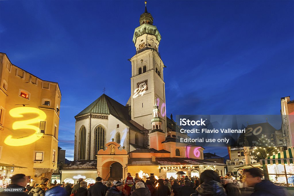 Christmas at Hall in Tirol, Austria Hall in Tirol, Austria - December 17, 2013: People at the tiny Christmas market in the historic city centre of Hall in Tirol. The dates of the advent calendar are projected on the buildings facades. Architecture Stock Photo