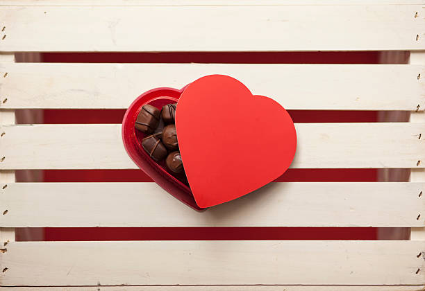 Scatola a forma di cuore con cioccolato su un bianco cassetta - foto stock