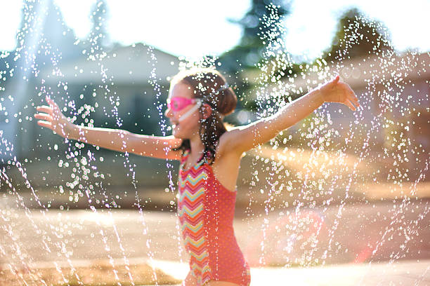 istock Young girl runs through the sprinkler 504241288
